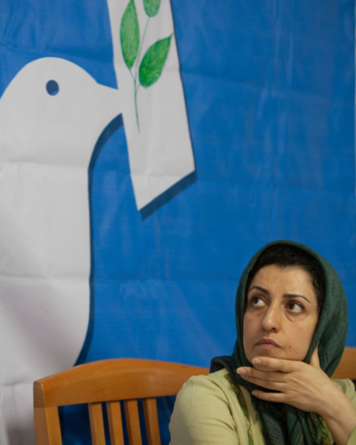Iranian female human rights activist, Narges Mohammadi, looks on while attending a session in the former office of the Defenders of Human Rights Association in central Tehran, Iran. There is an image of a white dove behind her.
Photo by Getty Images by Morteza Nikoubazl/NurPhoto