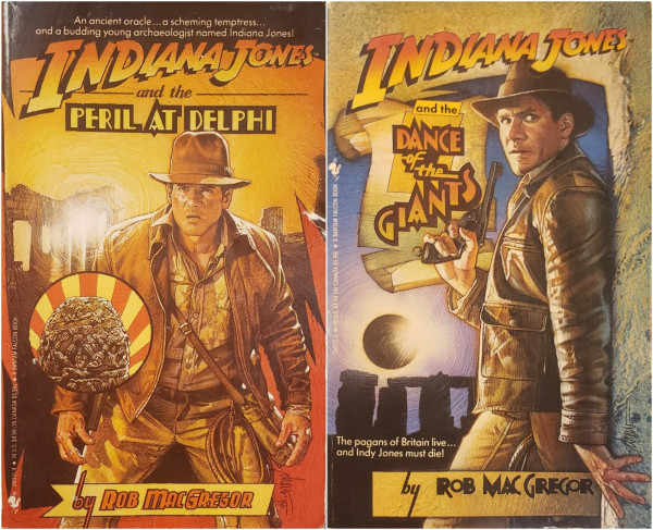 Two Indiana Jones paperback novels by Rob MacGregor, arranged side by side.

On the left is "Indiana Jones and the Peril at Delphi" – An ancient oracle... a scheming temptress... and a budding young archaeologist named Indiana Jones!
The hero wearing his trademark fedora, whip on his belt, in his classic adventure garb stands in the blazing sun, facing the reader, ready for action in front of Greek ruins. A worn but ornately decorated stone egg is highlighted in a circle, not part of the scene, but as the treasured object of this story.

On the right is "Indiana Jones and the Dance of the Giants" – The Pagans of Britain live... and Indy Jones must die!
Indy, his back to a stone pillar, a large revolver in hand, tries to remain hidden from an unseen enemy. In the background is Stonehenge at night on the verge of a Lunar eclipse.