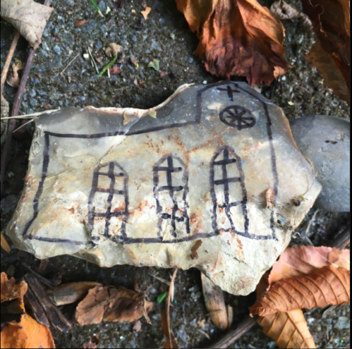 What looks a lot like a flint arrow head found by a group of school children and drawn upon with an image of a church.