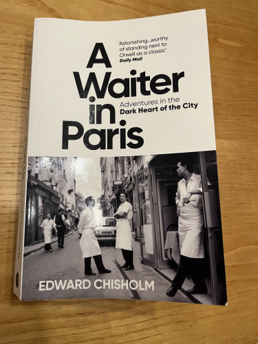 Cover of A Waiter in Paris by Edward Chisholm. Cover photo is of a group of waiters milling in a Parisian street. Milling around, that is, not, like, milling flour or something. That would be weird.