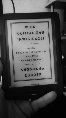 czarno-białe zdjęcie czytnika ebooków z okładką książki. 