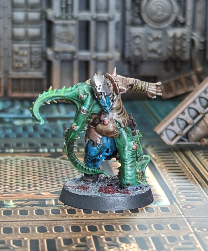 A Warhammer 40k chaos cultists mutant mini. His leg abs arm are chonky Cthulhu things with eyes all over.