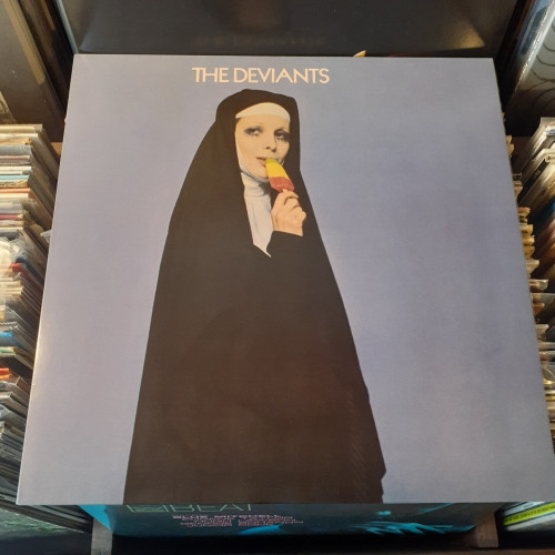 Album cover features photo of a woman dressed in a nun's smock, eating a multicolored popsicle. She's wearing heavy mascara, and looks like she could be somewhat deviant.