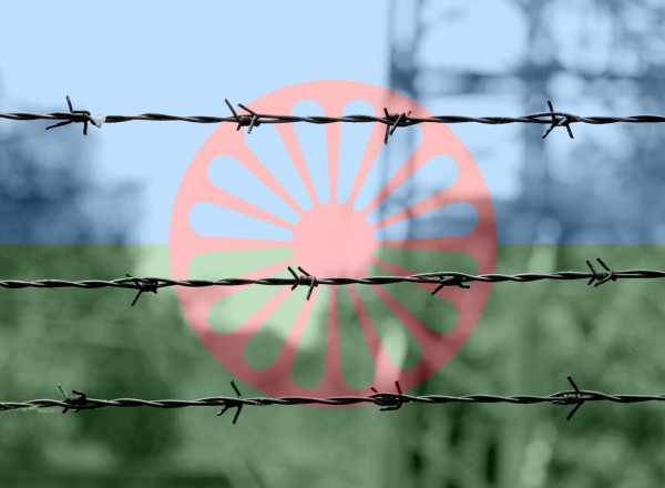  A photo showing barbed wire, with the Roma flag in the background. 