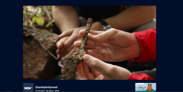 Screenshot aus der ARD-Mediathek mit einem Beitrag aus der "Sendung mit der Maus". Zwei Hände halten ein stark verrostetes Werkzeug. 