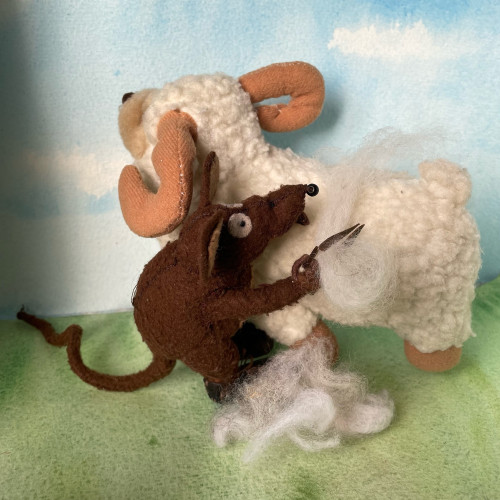 Photo of Minimus the Latin mouse shearing a plush sheep with traditional clippers