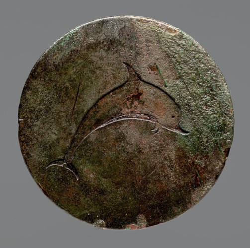 Description from the museum: “The image of the dolphin etched into the disk, symbolizing the trajectory of the disc, was obviously set in polychrome material: the abdomen, caudal and dorsal fins, beak and pelvic fins are separated from the rest of the body by lines. The edge is partly undercut, partly left rough to ensure better adhesion to the bedding.