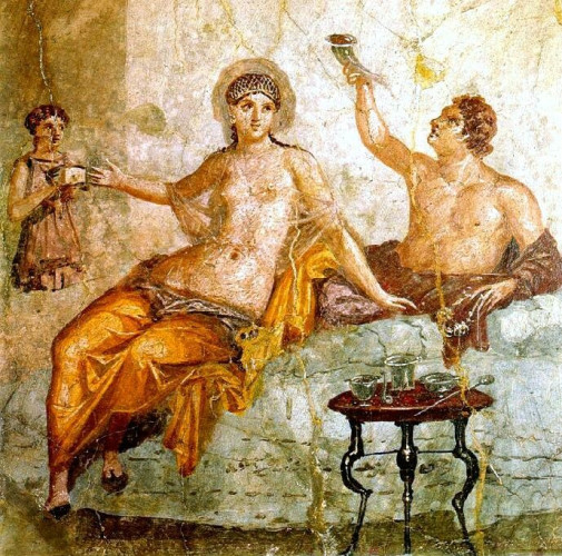 A banquet scene showing a man and woman reclining together. The woman wears a see-through gown from the waist up and golden robes below. The man wears a red-brown robe with chest bare. They are attended by a woman who seems to be missing part of her lower body.