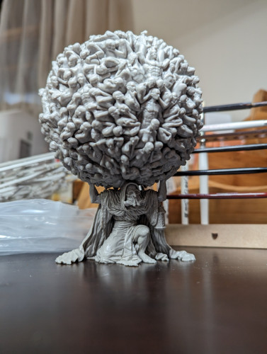 A "boutique horror" mini from Kingdom Death: Monster. Modeled after Atlas, he is holding on his back a mass of nude human forms shaped into a ball.
