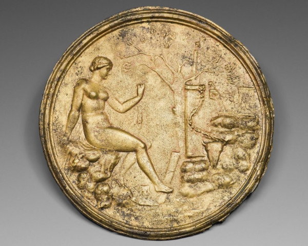 Description from the museum: “Artemis (the Roman Diana), or a Roman lady with divine fantasies, after her bath in a rustic, woodland setting, is the subject of the tondo in relief on the back of this Roman hand mirror. Her cloak is draped over the rocks on which she sits, and she holds the end wrapped around a small hand mirror in her raised left hand, a divine celebration of the uses of the mirror in a Roman household... The quiver of the goddess leans against the base of a garlanded altar with a small herm on top. A second terminal figure, Priapis, the god of gardens and fertility, tilts back while facing to the right on the ledge at the right. The bovine skull in the right foreground suggests the sacrifice after a successful hunt.”