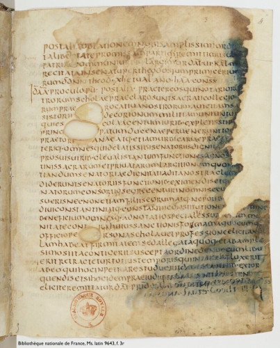 Photo of a leaf from a medieval manuscript: folio 3 recto in Bibliothèque nationale de France, Manuscrit latin 9643. The page contains 29 lines of Latin text written in a clear hand using dark brown ink, plus a modern institutional stamp in red ink. The parchment is of poorer quality with sizeable holes around which the scribe has written. Compounding this, the fore-edge is torn or eaten away and bears translucent blue stains, some extending nearly to the middle of the page, perhaps caused by deterioration of some reagent applied to protect the fore-edges of the leaves or to improve legibility of the text in already-damaged areas. Where the stains appear, the ink has darkened and some show-through from the other side of the leaf is apparent.