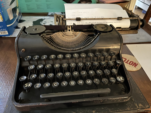 An old typewriter on a table. The writing on the paper reads “I am very much enjoying this ultra mechanical keyboard.”