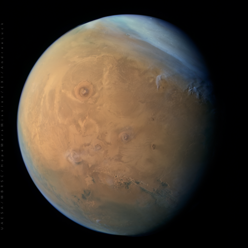 Hope Probe released this image of a cloudy Mars, showcasing Olympus Mons and Valles Marineris. The colours appear as rusty red on the surface and whitish hues over the clouds..