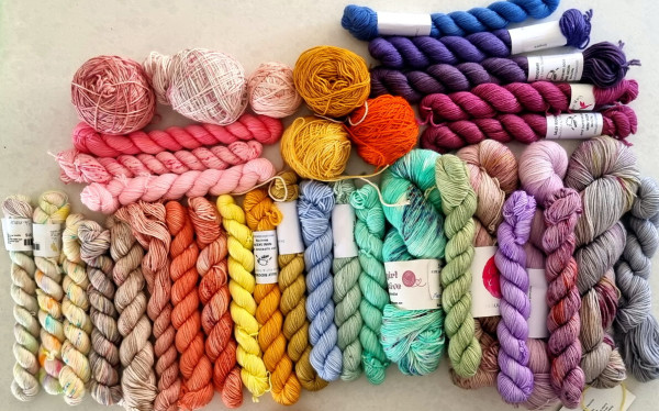 Skeins of yarn in all the colours of the rainbow, some variagated or speckled.