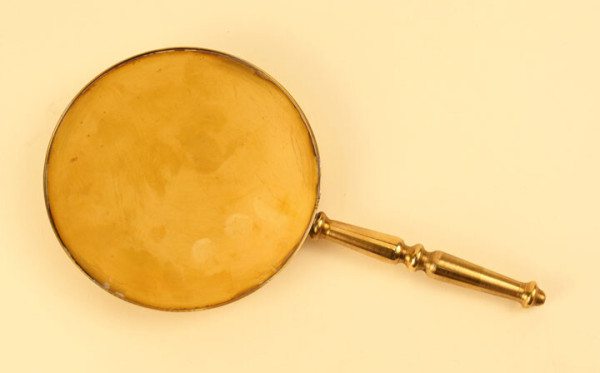 Photograph of a brass handheld mirror, a replication of an ancient Roman bronze mirror from Pompeii.