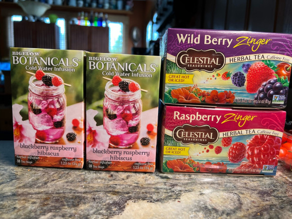 Four boxes of hibiscus-based tea bags with which my wife will make iced tea: 2 Bigelow Botanicals Blackberry Raspberry Hibiscus, 1 Celestial Seasonings Wild Berry Zinger, and 1 Celestial Seasonings Raspberry Zinger.