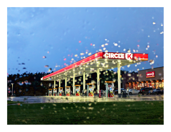 a circle k convenience store and fuel station at dusk under a stormy sky. it's been raining, and the picture was snapped out the passenger-side window of my car.