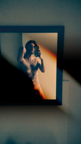 flux taking a nude selfie in front of his bathroom mirror in low light with censored graphics.