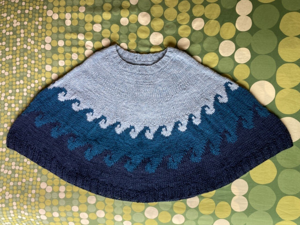 Knit poncho in three shades of blue, with colorwork waves