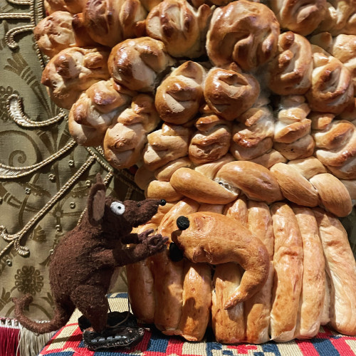 Photo of Minimus, the Latin mouse, next to a fancy harvest loaf shaped like a wheatsheaf. He is apparently talking to the bread mouse with raisin eyes that is part of the loaf.