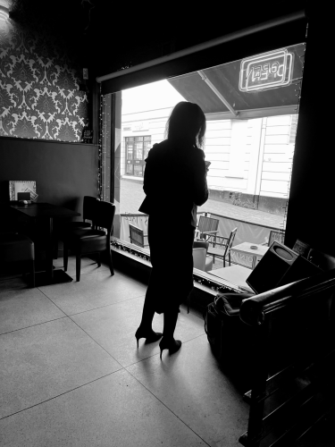 Black and white picture of the artist Serena Smith while preparing for her gig at the jazz café in Lincoln. Her silhouette in front of the main window 