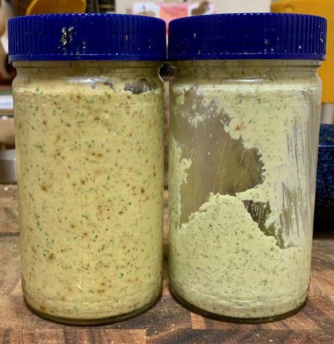 Two clear-glass jars with blue caps, one filed with a slightly pink sauce, the other with a light-green sauce.
