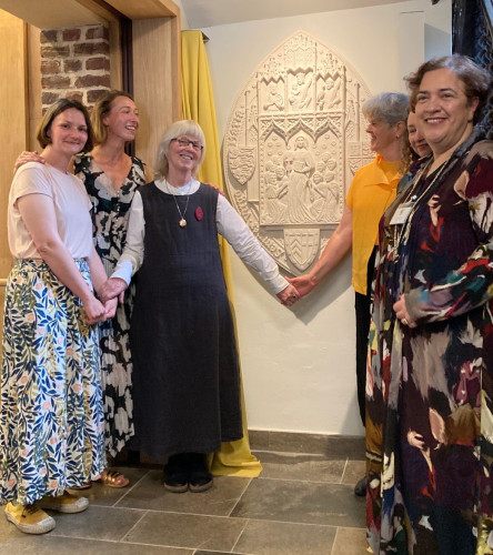 The new sculpture, about 4 feet high, mounted on the wall, with three of the stonecarvers on the left, and three members of Clare College on the right - united in a moment of joy at completion of the project.