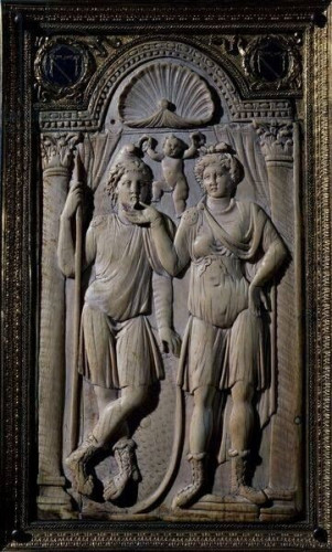 One plate of a diptych showing a relief of two figures. The man on the left wears a Phrygian cap, a simple chiton and hunting boots. He is holding a shepherd staff. On the right, a woman stands beside him, gesturing to him. She wears a top-bow hairstyle often seen on Aphrodite but also Artemis and her Roman counterpart Diana. She is also wearing a short chiton which is typical of Artemis-Diana and she is wearing hunting boots as well. Above them, a baby Eros symbolises their love and desire.