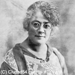  Ercilia Pepín in black & white photo. Woman smiling slightly wearing round glasses, top decoraded with wide band of lace. early C20th 