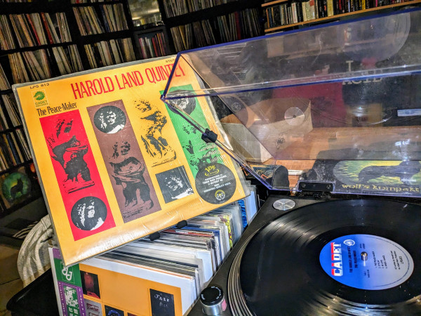 "Harold Land Quintet - The Peace-Maker" vinyl playing opn the Technics. Yellow front cover on the left. Record Collection shelves in the background. 