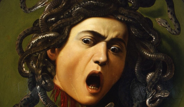 Detail of the (severed) head of Medusa painted by Caravaggio. Her eyes and mouth are wide open, realstic snakes wreathing around her head in the place of hair.