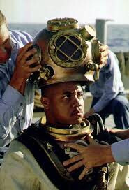 Photo of Cuba Gooding Jr getting suited up in a deep diver’s rig in a scene from the movie “Men of Honor”