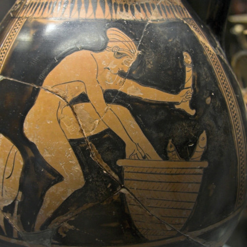 Attic red figure amphora depicting a naked woman seeming to step into a basket containing models of phalloi.  She also holds a phallus (dildo?) in one hand.