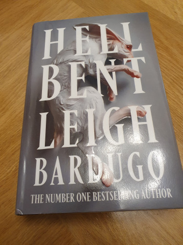 Book on the table. Theres's a white rabbit, grey backround and text Hell Bent. Leigh Bardugo. The number one bestselling author.