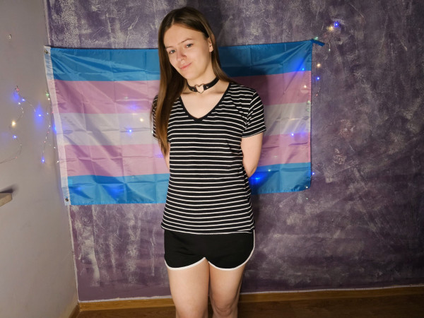 A photo of me. I have a trans flag in the background.