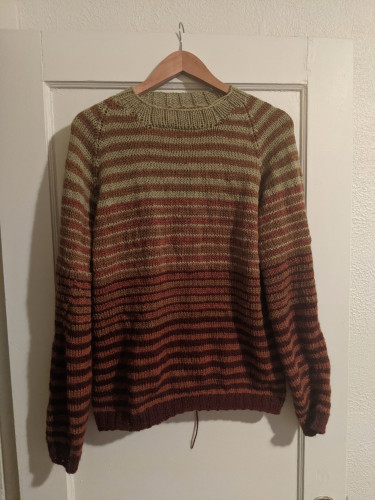My first ever knitted sweater, finished Jun 2023. It has stripes of green, brassy yellow, soft orange, and deep red