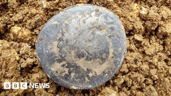 very weathered coin on a soil surface