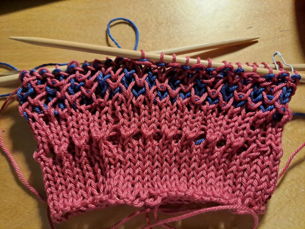 Start of a pink-blue bag, on knitting needles.