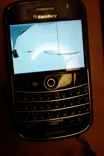 An old Blackberry phone with a smashed screen.