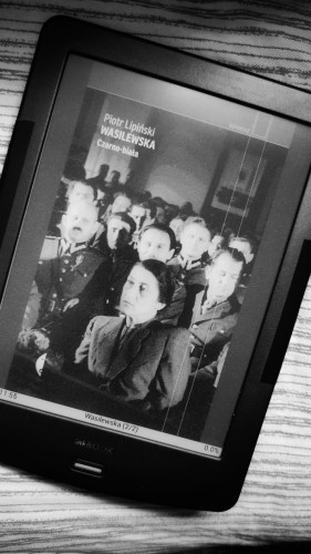 czarno-biale zdjęcie czytnika ebooków z okładką książki 