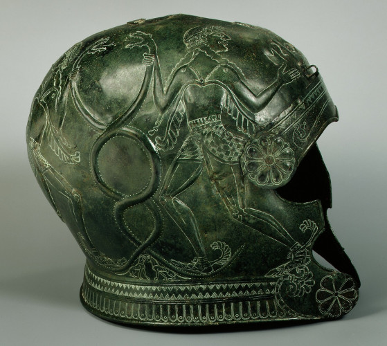 Description from the museum: “These helmets and the three mitrai exhibited below them are the finest pieces of a large cache of armor that came to light in southern central Crete, where it was undoubtedly made. The inscriptions suggest that the armor was captured as booty and offered as a dedication. In repoussé on both sides of one helmet is a pair of winged youths grasping a pair of intertwined snakes. Below them are two panthers with a common head. The helmet is inscribed "Neopolis." In repoussé on both sides of the other helmet is a horse; incised on each cheekpiece is a lion. The inscription states that Synenitos, the son of Euklotas, took this object.”