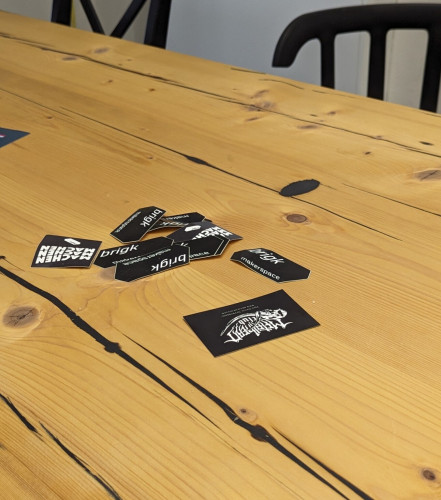 Table with stickers on it. Added a Metalhead.club Business card to the heap.