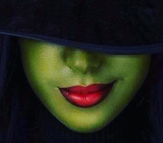 Lovely witch with black tip hat, green face, and full red lips.  She really is pretty as she smiles, even if the brow covers her eyes.  I wonder what spell she cast to make her smile like that?