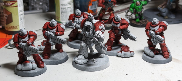 Six Warhammer 40k Space Marine miniatures. Five Infernus with flamers and a librarian in termination armor. Primed white with the armor painted red in the style of the Blood Angels. A lot of red. So much red. I need to buy more red.