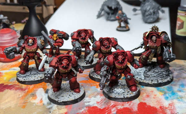 Warhammer 40k Space Marine terminators painted as Blood Angels. Almost completely painted, with red armor, black details, and rocky bases.
