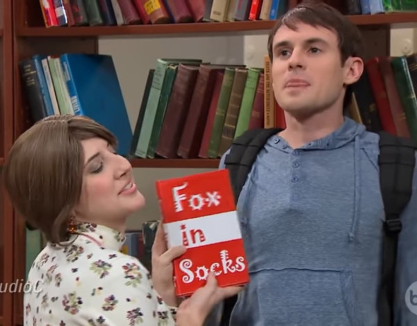 Screenshot of the skit from Studio C featuring Anne the Librarian holding a copy of the book “Fox in Socks”