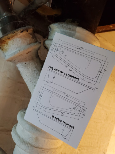 26th selection for The Sealey Challenge 2023 (reading 31 poetry works in the month of August): Poetry chapbook The Art of Plumbing by Brecken Hancock (above/ground press), with its black and white cover depicting bathtub diagrams, perches on the conjunction of some dusty white plumbing pipes