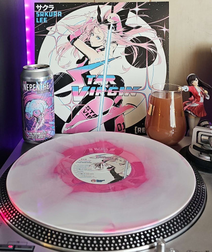 A Pink Milky Marble vinyl record sits on a turntable. Behind the turntable, a vinyl album outer sleeve is displayed. The front cover shows an anime girl holding a light sword and posing in front of the moon. 

To the right of the album cover is an anime figure of Yuki Morikawa singing in to a microphone and holding her arm out. 

On the turntable is a 16 oz can and a stemless glass filled with beer. The can art shows a disembodied brain with eyes. 