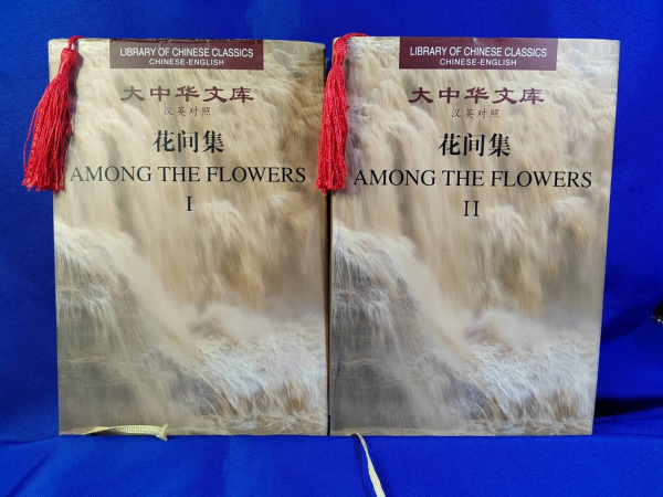 A picture of the classical Chinese poetry collection Among the Flowers volumes 1 and 2.  With tassled bookmarks.  In use.