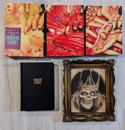 McSweeney's #71: THE MONSTROUS AND THE TERRIBLE shown with its series of nesting, interlocking slipcases covered in horrid goodness and A Haunted Mansion artprint of a ghoul in a very nice plastic frame.